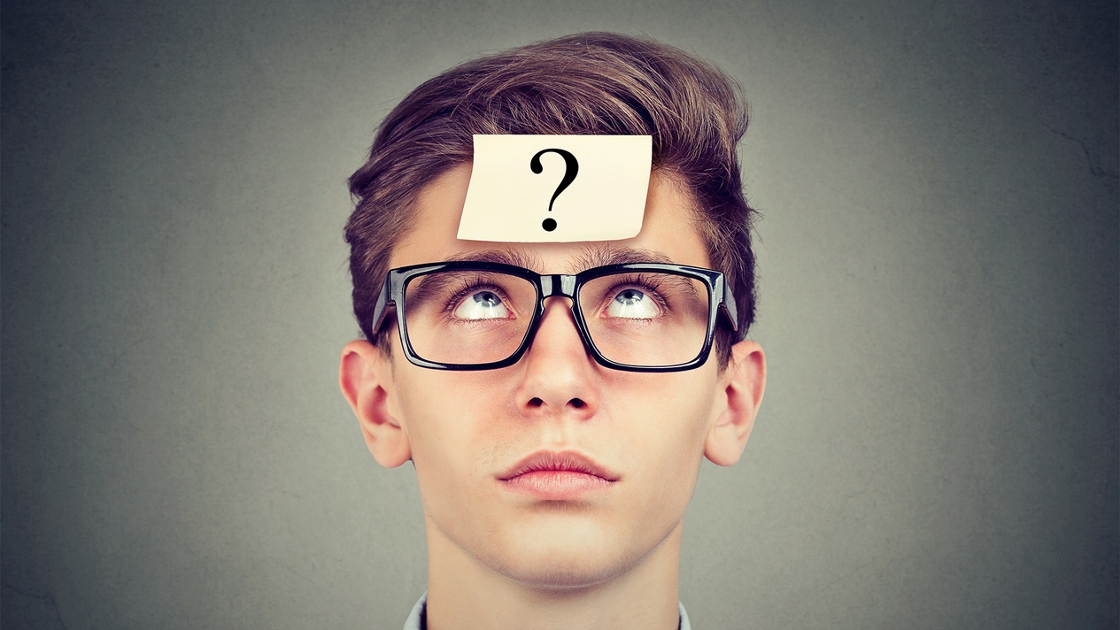 Teenager mit Brille blickt fragend nach oben, auf seiner Stirn klebt ein Zettel mit einem Fragezeichen. © pathdoc, stock.adobe.com